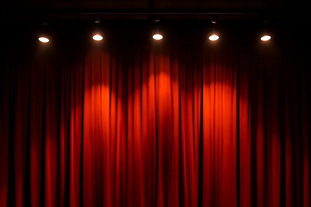 Scene de théâtre vide avec rideau rouge et projecteurs allumes avant une representation
